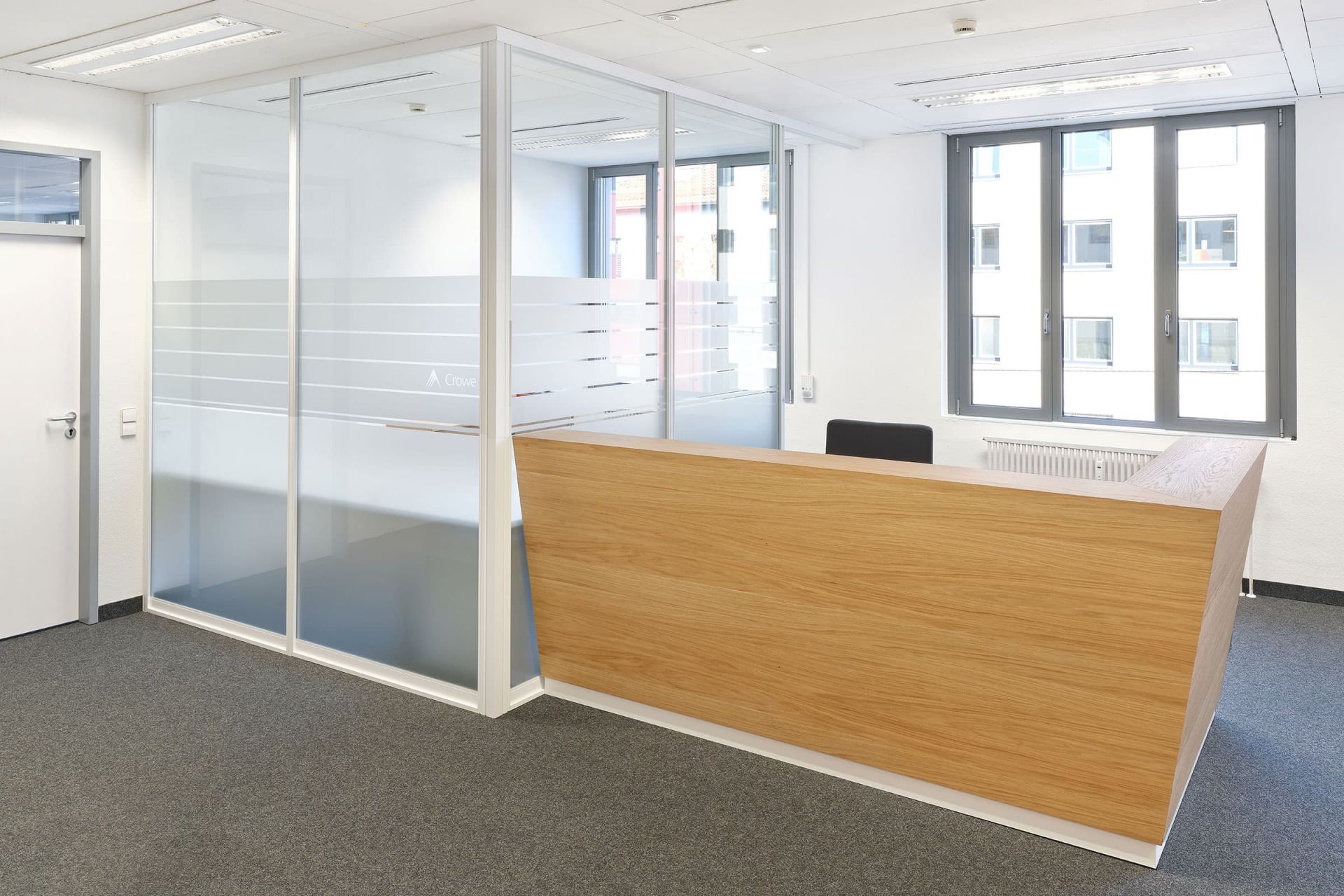 Passgenauer Empfangstresen aus Holz im modernen Bürogebäude, realisiert von der Echaz Schreinerei