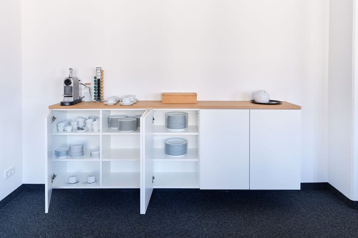Individuell gefertigtes Sideboard mit Stauraum und Holzarbeitsplatte im modernen Bürogebäude, umgesetzt von der Echaz Schreinerei