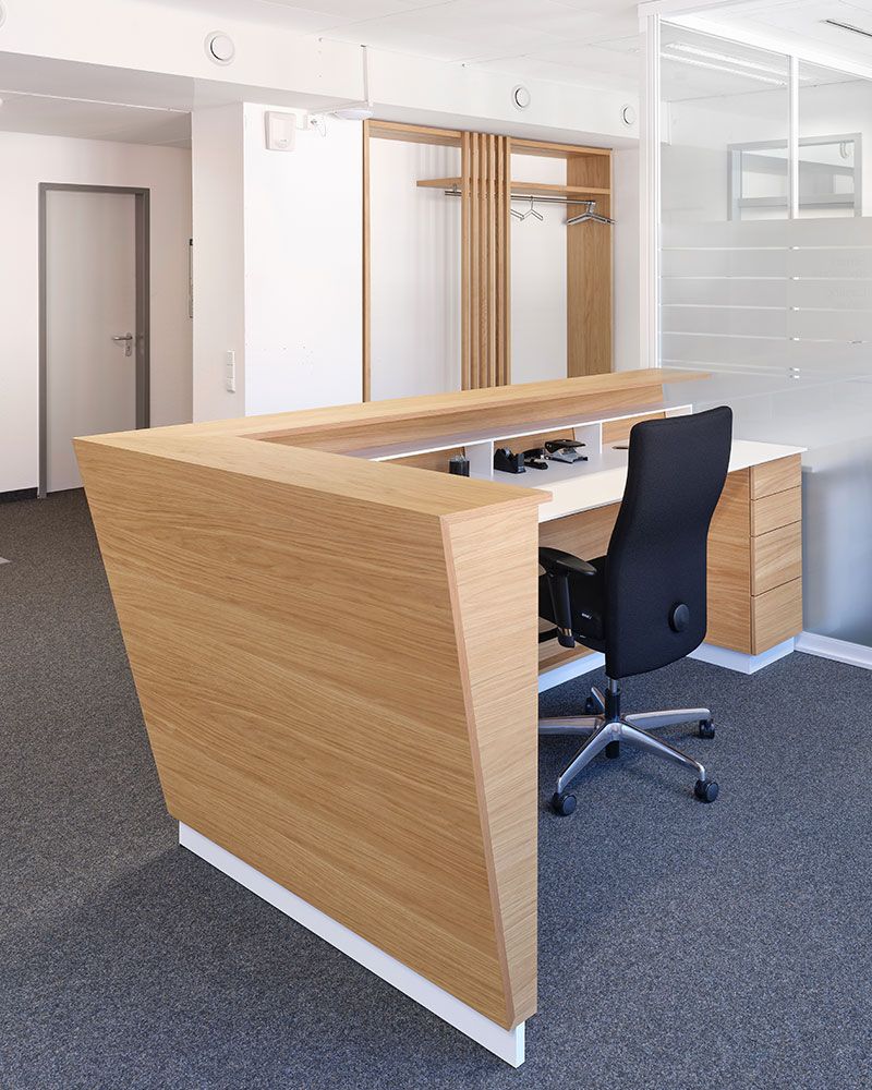 Moderner Empfangsarbeitsplatz mit Holzverkleidung, individuell gefertigt von der Echaz Schreinerei