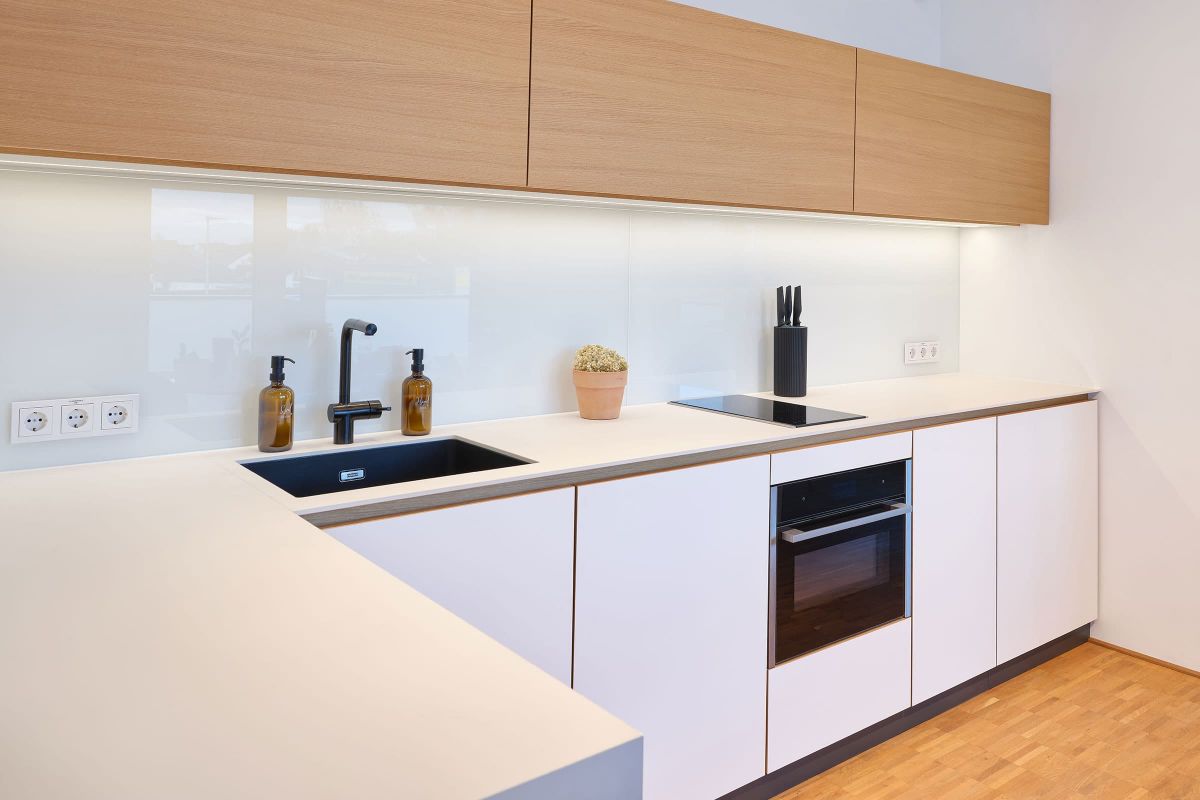 Detailansicht einer individuell gefertigten Praxisküche mit Holz- und weißen Fronten aus der Echaz Schreinerei