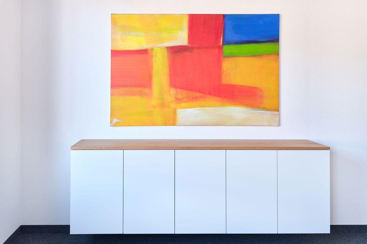 Modernes Sideboard aus Holz und weißen Fronten als Teil des individuellen Innenausbaus im Bürogebäude der Echaz Schreinerei