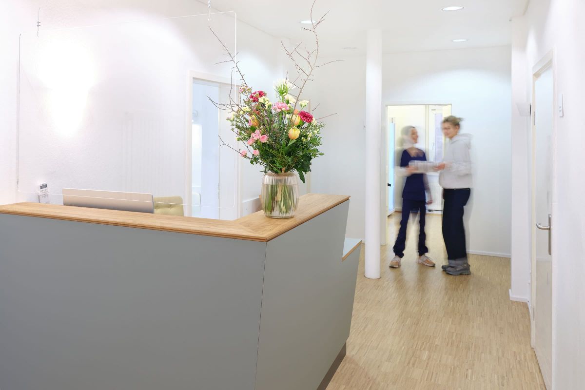 Individueller Empfangstresen mit Holzdetails in einer Praxis, realisiert von einer Schreinerei für funktionale Praxismöbel