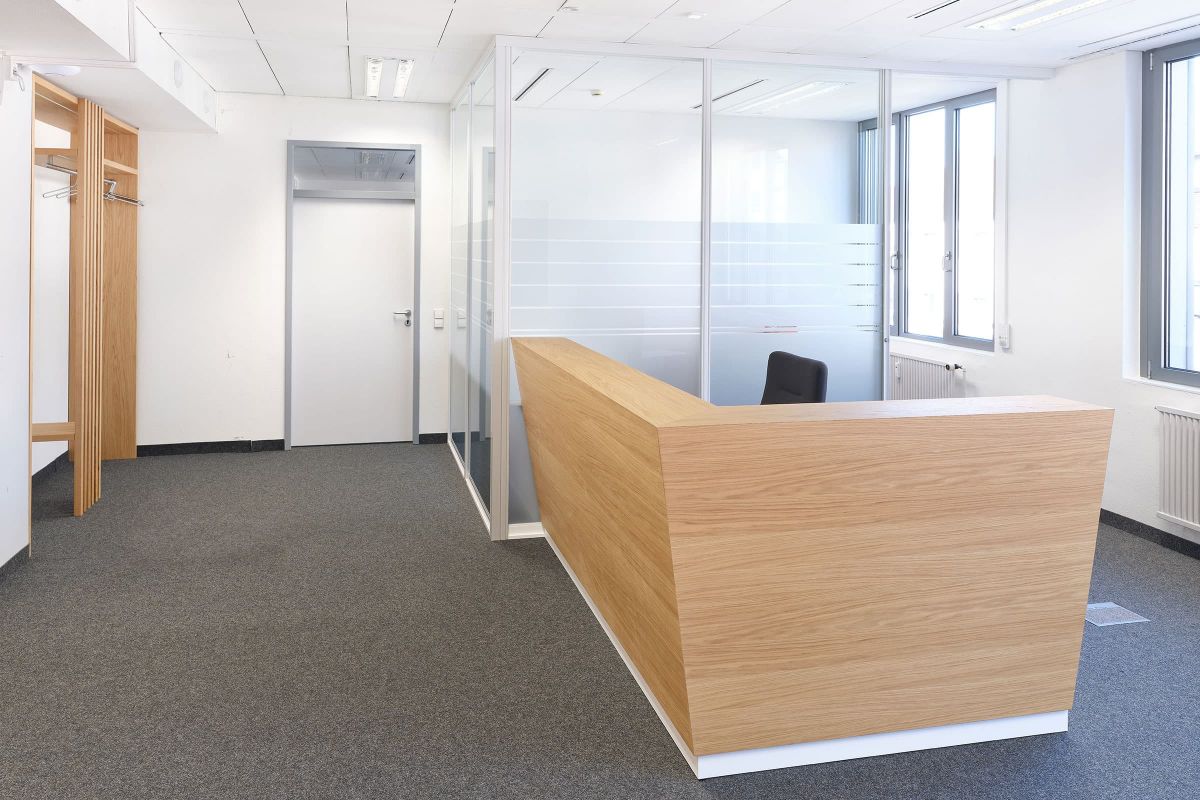 Moderner Empfangsbereich mit maßgefertigtem Holzempfangstresen und integrierter Garderobe