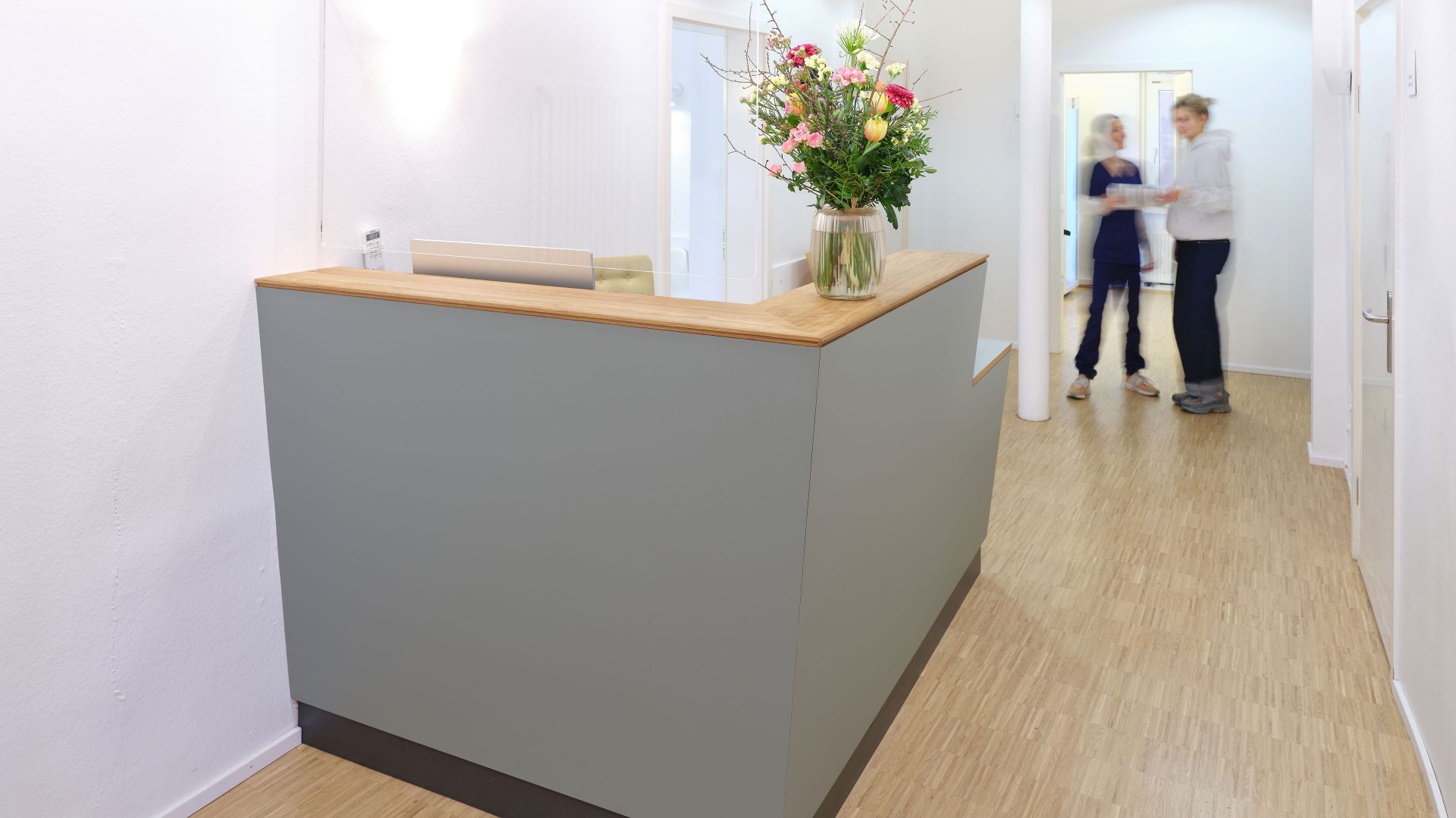 Maßgefertigter Empfangstresen aus Holz als Teil individueller Praxismöbel, realisiert von einer Schreinerei